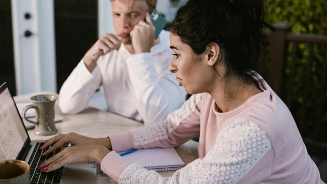 A couple reviewing financial documents and planning their budget together at home